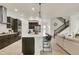 Modern kitchen features a large island with seating, dark cabinetry, and stainless steel appliances, open to the living area at 6619 Mariposa Ct, Denver, CO 80221