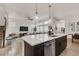 Kitchen island with seating overlooks the staircase and spacious living area at 6619 Mariposa Ct, Denver, CO 80221