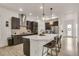 Modern kitchen with a large island, pendant lighting, stainless steel appliances, and dark cabinetry, offering ample counter space at 6619 Mariposa Ct, Denver, CO 80221