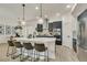 Modern kitchen with a white island, pendant lighting, stainless steel appliances and bar stool seating at 6619 Mariposa Ct, Denver, CO 80221