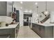 Open kitchen with a large island, pendant lights, stainless steel appliances, and a seamless flow to the staircase at 6619 Mariposa Ct, Denver, CO 80221
