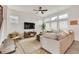 Bright living room featuring a sectional sofa, modern ceiling fan, and lots of natural light at 6619 Mariposa Ct, Denver, CO 80221