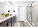 Bright bathroom featuring a double vanity with stone countertops and a glass-enclosed shower at 4739 Gray Wolf Ln, Castle Rock, CO 80104