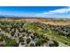 Aerial view of a residential area featuring a golf course, trees, housing and mountain views at 13516 Thorncreek Cir, Thornton, CO 80241