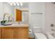 Bright bathroom showcasing wood cabinetry, a single sink, and white tiled walls at 13516 Thorncreek Cir, Thornton, CO 80241