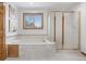 Bright bathroom featuring a soaking tub, glass shower, and tile surround at 13516 Thorncreek Cir, Thornton, CO 80241