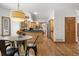 Open dining area featuring hardwood floors, a round table, and seamless access to the kitchen at 13516 Thorncreek Cir, Thornton, CO 80241