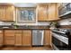 Functional kitchen featuring stainless steel appliances, a tile backsplash, and wood cabinets at 13516 Thorncreek Cir, Thornton, CO 80241