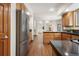 Well-lit kitchen with stainless steel appliances, wooden cabinetry, and hardwood flooring at 13516 Thorncreek Cir, Thornton, CO 80241