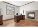 Home office featuring hardwood floors, a modern fireplace, and an abundance of natural light at 13516 Thorncreek Cir, Thornton, CO 80241