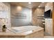 Luxurious bathroom featuring a soaking tub, marble finishes, and a glass-enclosed shower at 8833 Portico Ln, Longmont, CO 80503