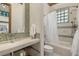 Modern bathroom featuring a sleek vanity, mosaic tile accents, and a shower with glass block window for natural light at 8833 Portico Ln, Longmont, CO 80503