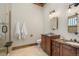 Elegant bathroom with double vanities, marble countertops, travertine floors, and a glass-enclosed shower, creating a spa-like experience at 8833 Portico Ln, Longmont, CO 80503