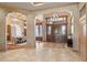 Elegant foyer with tile flooring and chandeliers, leading to a dining area with a large wooden front door at 8833 Portico Ln, Longmont, CO 80503