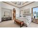 Comfortable primary bedroom with a coffered ceiling, seating area, and a connected spa-like bathroom at 8833 Portico Ln, Longmont, CO 80503