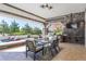 Outdoor dining area with stone columns, tile flooring, a built-in grill, and views of the backyard at 8833 Portico Ln, Longmont, CO 80503