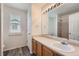 Bathroom features vanity with sink, large mirror with lighting, tile floors and a shower and bath at 22162 E Alamo Ln, Centennial, CO 80015