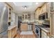 Well-lit kitchen with stainless steel appliances, granite countertops, and light wood cabinets at 4165 Winona Ct, Denver, CO 80212