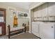 Bright laundry room with modern washer/dryer, ample storage, and a comfortable bench seating area at 4165 Winona Ct, Denver, CO 80212