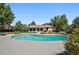 Aerial view of backyard with a pool, patio, green grass, trees, and foliage at 5197 S Perry St, Littleton, CO 80123