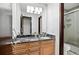 Bathroom boasts a vanity with granite countertop, wood cabinets, and a glass-enclosed shower at 5197 S Perry St, Littleton, CO 80123
