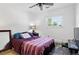 Bedroom features neutral walls, dark tile floor, and a window overlooking the outdoor greenery at 5197 S Perry St, Littleton, CO 80123