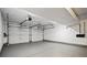 Spacious two-car garage with white walls, sealed concrete floors, and two garage doors at 5197 S Perry St, Littleton, CO 80123