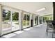 Sunroom with many sliding glass doors and a view of the lawn, trees, and pool at 5197 S Perry St, Littleton, CO 80123