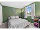 Comfortable bedroom with green wall, white trim, large window, and a soft patterned comforter at 6502 W 96Th Ave, Westminster, CO 80021