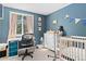 Bedroom with blue walls, a crib, a changing table, and a desk near a window at 6502 W 96Th Ave, Westminster, CO 80021