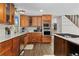 Bright kitchen with stainless steel appliances, wood cabinetry, a window above the sink, and hardwood flooring at 6502 W 96Th Ave, Westminster, CO 80021