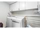 Functional laundry room with a washer, dryer, and overhead cabinets for ample storage space at 6502 W 96Th Ave, Westminster, CO 80021