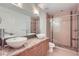Elegant bathroom with double sinks, granite countertop, and glass-enclosed shower featuring pebble flooring at 2650 W Front View Crescent Dr # 101, Denver, CO 80211
