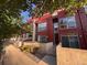 Stylish townhome exterior featuring modern design, red accents, and a walkway leading to the entrance at 2650 W Front View Crescent Dr # 101, Denver, CO 80211