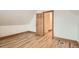 Bright bedroom featuring light hardwood floors, white walls, trim detail, and an open door to an upstairs hallway at 160 W Bayaud Ave, Denver, CO 80223