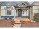 Charming front porch with wooden decking and decorative columns, complemented by potted flowers at 160 W Bayaud Ave, Denver, CO 80223