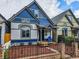 Charming two-story home with blue exterior, well-manicured lawn, and inviting front porch with a blue chair at 160 W Bayaud Ave, Denver, CO 80223