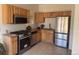 A bright kitchen showcases stainless steel appliances and wood cabinets at 160 W Bayaud Ave, Denver, CO 80223
