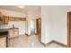 View of the kitchen, highlighting the tile floor, wooden cabinets, and access to another room at 160 W Bayaud Ave, Denver, CO 80223