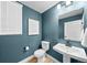 A modern half bath with dark teal walls and a white vanity with a vessel sink at 17112 W 91St Ln, Arvada, CO 80007
