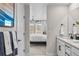 Bright bathroom with double sinks and a view into the bedroom with large windows and bright sunlight at 17112 W 91St Ln, Arvada, CO 80007