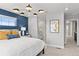 Stylish bedroom with a blue accent wall and modern light fixture, leading to bathroom and hallway at 17112 W 91St Ln, Arvada, CO 80007