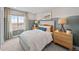 Comfortable bedroom featuring a large window with views, a bed, and bedside tables at 17112 W 91St Ln, Arvada, CO 80007