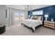 Bright bedroom featuring a large bed, modern lighting, and contrasting accent wall at 17112 W 91St Ln, Arvada, CO 80007