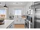 Modern kitchen featuring white cabinets, stainless steel appliances, and an island with a white countertop at 17112 W 91St Ln, Arvada, CO 80007
