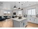Open concept kitchen and living room with a large island, hardwood floors, and lots of natural light at 17112 W 91St Ln, Arvada, CO 80007