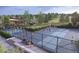 Community pickleball courts surrounded by native landscaping and a clubhouse for recreation at 17112 W 91St Ln, Arvada, CO 80007