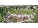Aerial view of a vibrant community playground surrounded by lush greenery and walking paths at 17112 W 91St Ln, Arvada, CO 80007