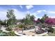 Community playground with walking paths surrounded by lush landscaping and seating areas at 17112 W 91St Ln, Arvada, CO 80007