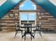 Cozy dining area with wood accent wall, modern chandelier, and expansive views from the triangular peak window at 197 Sawmill Ln, Idaho Springs, CO 80452